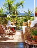 Sunny terrace seating area - wicker sofa and armchair with curved metal frame in front of palm trees and sea view