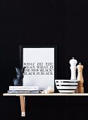 Kitchen utensils and framed motto on bracket shelf against black background