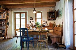 Rustic kitchen with wooden ceiling, dining table, wooden chairs & corner bench