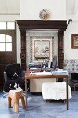 Desk below vintage tiled picture with frame and wooden surround in renovated country house