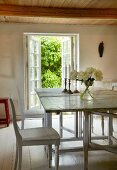 White wooden table and chairs in dining room with white wooden floor