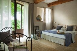 Double bed in rustic, elegant bedroom in French country house