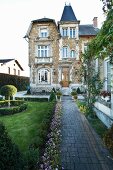 Château mit Natursteinfassade und geometrisch angelegtem Garten