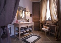 Spacious bathroom with heavy, gathered curtains and long, wooden washstand