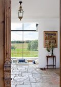 View into living area of detached house with rustic stone floor and large panoramic windows