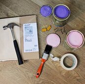 Paint pots, masking tape and tools next to a storage box still in its package