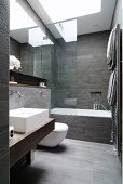 Designer bathroom with grey-tiled walls and floor