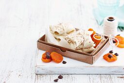 Crepe packages in a box with dried apricots and chocolate chips