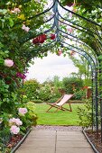Rose-covered archway in summer garden