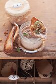 Sausage spread in a screw-top jar with a slice of toast on top and next to it