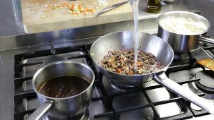 Bolognese sauce being made: pasta water being added to the meat and vegetable mixture