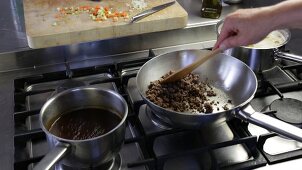 Sauce Bolognese zubereiten: Hackfleisch in einer Pfanne anberaten