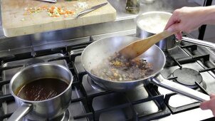 Bolognese sauce being made: minced meat and vegetable mixture simmering in a pan