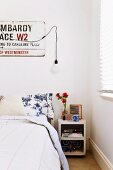 Bedroom with street sign on wall and retro bedside cabinet