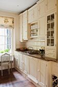 Fitted kitchen in traditional country-house style with white coffered fronts and granite worksurface