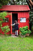 Red garden shed with a corrugated iron roof