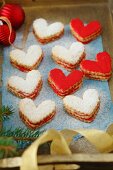 Heart-shaped Christmas biscuits with red icing and icing sugar