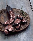 Bavarian black pudding on a bread platter with a sprig of thyme