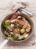 Fried potatoes with root vegetables, spring onions, bacon and herbs
