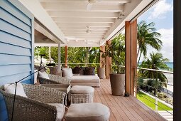 Roofed balcony with comfortable seating and view of palm trees and beach