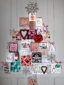Weihnachtskarten in Tannenbaumform arrangiert an der Wand