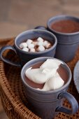 Cups of cocoa with cream and marshmallows