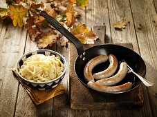 Pork sausages in a pan with tagliatelle