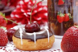 A doughnut with cherries and chocolate glaze