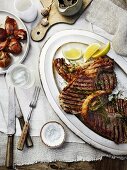 Barbecued T-bone steak with herb oil and onions cooked with Taleggio cheese