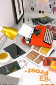 Orange typewriter and gold table lamp on desk