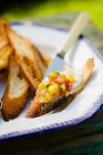 Peach Salsa on a Slice of Toasted Bread; On a Dish with Slices of Toasted Bread