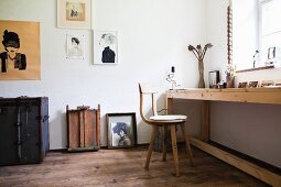 Langer Holztisch mit Holzstuhl vor dem Fenster, moderne Portraits an der Wand in einem Zimmer mit Dielenboden