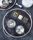 A Tray with Two Martinis and Three Bowls of Assorted Olives and Onions; From Above