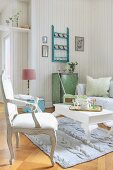 Wohnzimmer mit Vintage-Möbeln, gestricktem Teppich und gestreifter Tapete