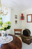 Red ship's lamp in corner of room above stack of antique trunks