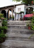 Steinstufen im Garten vor Gebäude mit Veranda