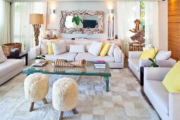 Fur-covered stools, driftwood artworks and huge seashells decorating inviting seating area with set of sofas
