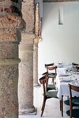 Set table in arcade with heavy stone columns in courtyard