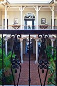 View into elegant hotel courtyard with colonnade from balcony with wrought iron balustrade