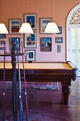 Billiard room with framed pictures on apricot walls