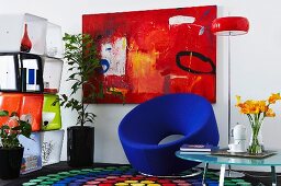 Sitzecke mit Sammlung poppiger 80er Jahre Möbel vor rotem Wandgemälde