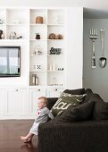 Open-plan interior with sofa & white fitted shelving