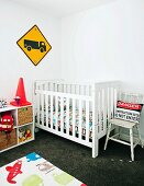 Kinderzimmer mit Gitterbett aus Holz, Spielzeugregal & Kinderteppich