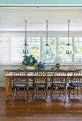 Windsor chairs at long rustic dining table in sunny dining room