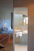 Beton als vorherrschendes Material in minimalistischem Hotelzimmer mit Bad Ensuite; interessantes Spiel mit Spiegelbildern