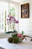 Flower arrangement on table in front of open window