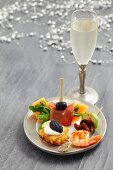 A plate of Christmassy appetisers and a glass of sparkling wine