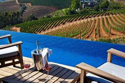 Blauer Infinity Pool mit Blick auf bewirtschaftete Weinberge