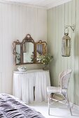 Geschwungener Wandtisch mit weißem Vorhang und aufgehängter Wandspiegel mit Goldrahmen in holzverkleideter Zimmerecke