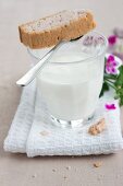 Glass of milk and shortbread with scented geranium oil